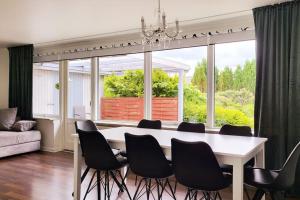 ein Esszimmer mit einem weißen Tisch und schwarzen Stühlen in der Unterkunft Thuya Rica house (1.6km to Legoland) in Billund