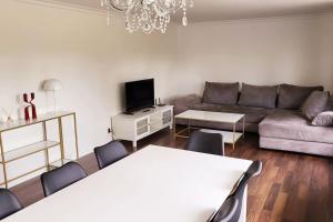 ein Wohnzimmer mit einer Couch und einem Tisch und Stühlen in der Unterkunft Thuya Rica house (1.6km to Legoland) in Billund