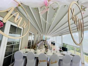 a long dining room with a long table with white chairs at Strandhotel Vier Jahreszeiten Buckow in Buckow