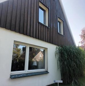 uma casa com duas janelas do lado em De Dackluuk em Wittmund