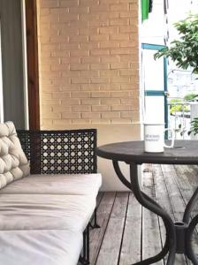 una mesa y un banco sentados en un porche en Hongdae Luxury Private Single House with Big Open Balcony Perfect for a Family & Big Group 3BR, 5QB & 1SB, 2Toilet en Seúl