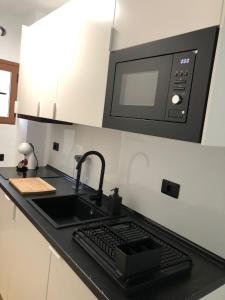 a kitchen with a sink and a microwave at Tu apartamento en vacaciones in Puerto de la Cruz