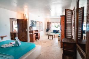 una habitación con una cama con un animal de peluche. en Pili Pili Uhuru Beach Hotel, en Jambiani