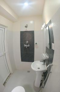 a white bathroom with a sink and a toilet at Hotel Down To Earth in Kathmandu