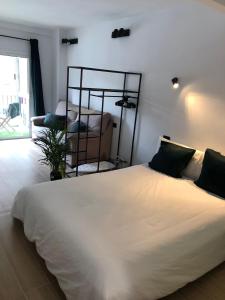 a bedroom with a large white bed in a room at Tu apartamento en vacaciones in Puerto de la Cruz