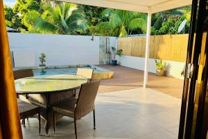 une terrasse avec une table et des chaises ainsi qu'une piscine dans l'établissement Muna house and private pool - AC - optic fiber Wi-Fi - 3 pers, à Punaauia
