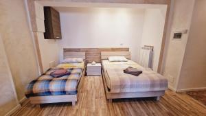 2 aparte bedden in een kamer met houten vloeren bij Soleluna in Piacenza