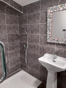 a bathroom with a shower and a sink and a mirror at le jardin in Montélimar