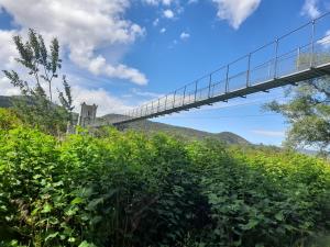 een brug over een heuvel met bomen en struiken bij le jardin in Montélimar