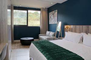 ein Hotelzimmer mit einem großen Bett und einem Sofa in der Unterkunft Zimbali Lakes Boulevard Suite 257 in Ballito