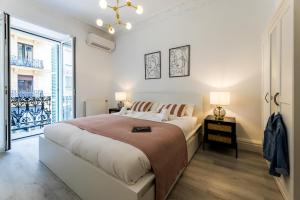 a white bedroom with a large bed and a window at BALEA Suite apartment in San Sebastián