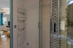 a shower in a bathroom with a glass door at M comme Meursault in Meursault