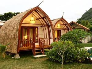 two domes with chairs and a porch in the grass at OUTSIDE bungalow in Sekongkang