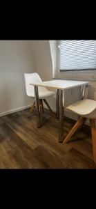 einen Tisch und zwei Stühle in einem Zimmer mit Fenster in der Unterkunft Casa qui Piccola Eifel in Hellenthal