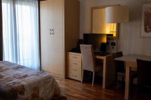 a hotel room with a desk and a bed and a table at Aparthotel Cianfuran Residence in Bardonecchia