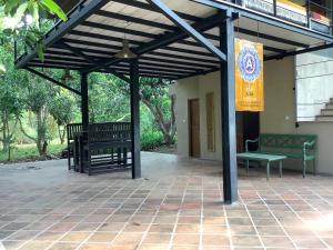 a patio with two benches and a flag on a building at Mind Body and Soul in Dambulla