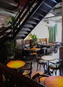 a restaurant with tables and chairs and a staircase at Sonderia Hostel & Bar - Lazybones Hostel in Chengdu