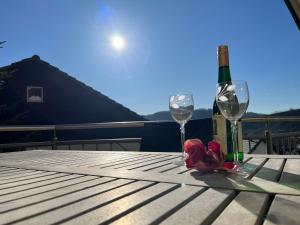 a bottle of wine and two glasses on a table at Ferienwohnung Mosel in Niederfell