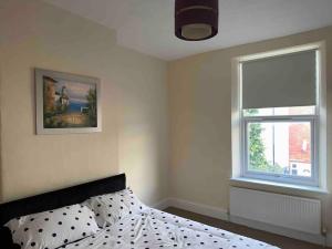 a bedroom with a bed and a window at Clevedon House in Manchester