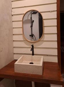 a bathroom sink with a mirror on a wooden table at OUTSIDE bungalow in Sekongkang