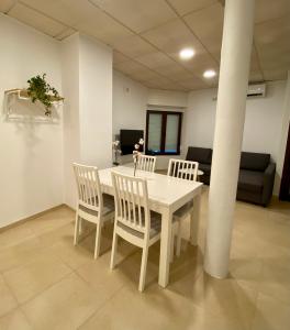 Aeropuerto-Churriana-Golf في مالقة: طاولة بيضاء وكراسي في غرفة
