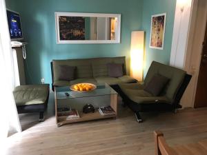 uma sala de estar com um sofá e duas cadeiras em Flat31 em Atenas