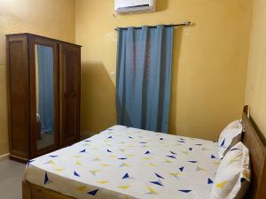 a bedroom with a bed and a blue curtain at Le Poulagou in Saint-Louis