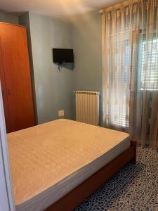 Un dormitorio con una cama y un televisor en la pared. en VILLA a MARE, en Villammare