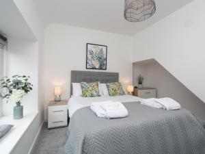 a bedroom with a bed with two towels on it at Modern 2 bed Apartment in Rhosneigr - Pass the Keys in Gwalchmai