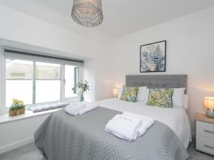 a bedroom with a bed with two towels on it at Modern 2 bed Apartment in Rhosneigr - Pass the Keys in Gwalchmai
