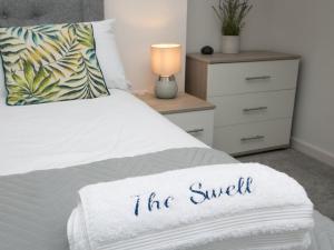 a bed with a white blanket that says the snuggle at Modern 2 bed Apartment in Rhosneigr - Pass the Keys in Gwalchmai +27 photos