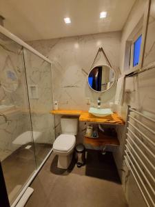 a bathroom with a shower and a toilet and a mirror at Parador dos Canyons in Cambara do Sul