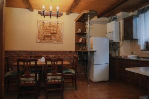 una cucina con tavolo, sedie e frigorifero di Dereviy a Jaremče