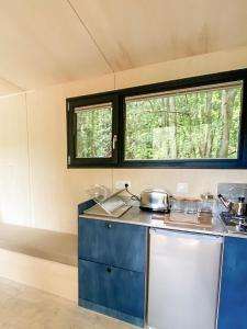 eine Küche in einem winzigen Haus mit Töpfen und Pfannen in der Unterkunft Le repaire des impressionnistes in Amenucourt