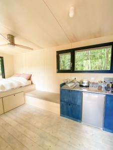 eine Küche in einem winzigen Haus mit einem Bett in der Unterkunft Le repaire des impressionnistes in Amenucourt