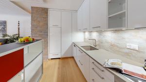 a kitchen with white cabinets and a counter top at Chasa Vista Pisoc in Scuol