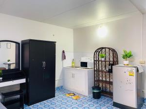 a kitchen with a black cabinet and a refrigerator at Condo popular T8 Fl.5 in Thung Si Kan