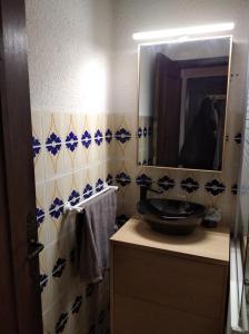 een badkamer met een wastafel en een spiegel bij Studio à la montagne in Valdeblore