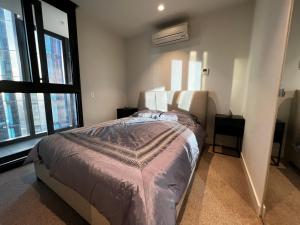 ein Schlafzimmer mit einem Bett und einem großen Fenster in der Unterkunft City Central Location, Parking and 2 Bed Apartment in Melbourne + 6 Fotos