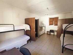 a room with two bunk beds and a desk at Eco Ostello Grisolia in Grisolia