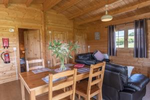a dining room with a table and a couch at Moor View Cabin (Oak Tree Lane) in Okehampton