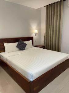 1 dormitorio con 1 cama grande con sábanas blancas en Chhay Ing Guesthouse, 