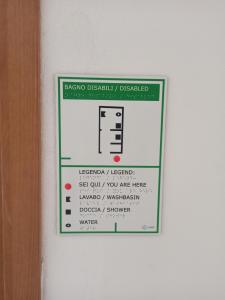 a sign is posted on a white wall at Eco Ostello Grisolia in Grisolia