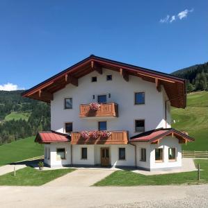 un gran edificio blanco con balcón en una colina en Bio Schartenhof en Sankt Johann im Pongau