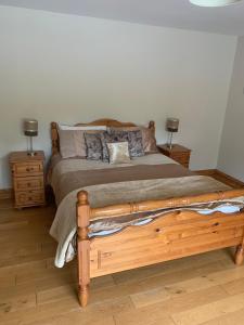 1 dormitorio con 1 cama de madera y 2 mesitas de noche en Camino House, en Tralee