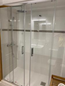 um chuveiro com portas de vidro na casa de banho em Sopela Etxea em Sopelana
