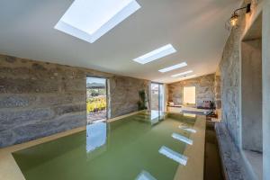 einen Pool in einem Zimmer mit einer Steinmauer in der Unterkunft Lemon Villa-indoor pool in Valpedre
