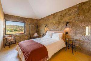 Un dormitorio con una cama grande y una pared de piedra. en Lemon Villa-indoor pool, en Valpedre 12 fotos más