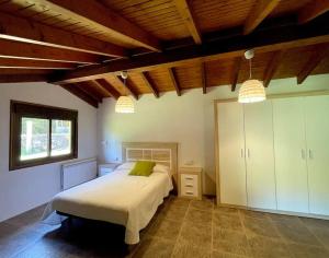 a bedroom with a bed in a room with wooden ceilings at Espectacular casa en Covelo in Covelo