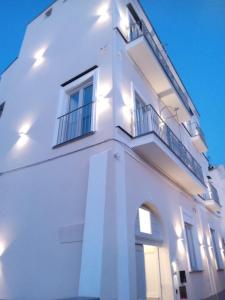 Edificio blanco con 2 ventanas y balcón en Palazzo Palumbo en Procida